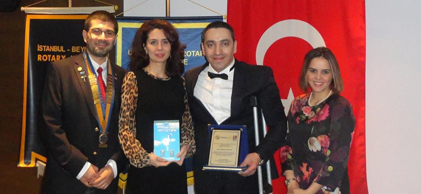 Resim: Sahnede plaket verildikten sonra yan yana Mehmet Kızıltaş, Hasibe Kızıltaş, Berfu Babuçcu ve Sarıyer Rotary Dönem Başkanının olduğu toplu resim.